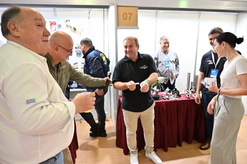 Asistentes conversando en uno de los stands del salón de exposiciones